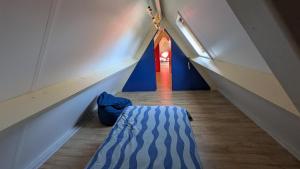a hallway with a bed and a red door at Guesthouse 10 in Schellinkhout