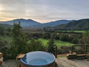 a hot tub on a deck with a view of mountains at Vistas de Quillay in Casablanca
