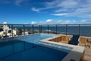 a swimming pool with a view of the ocean at Para quem deseja conforto e bem estar in Salvador