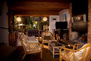 a living room with chairs and a fireplace at Kahukura in Kuaotunu