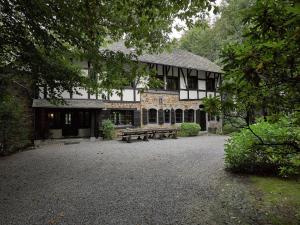 Un gran edificio con un banco delante. en Spacious Villa in Liège, en Spa