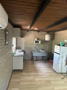 a kitchen with a refrigerator and a table in a room at Casa Verde en Jaureguiberry in Jaureguiberry
