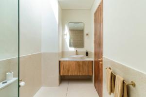 a bathroom with a sink and a mirror at Modern 3BR Villa, Rooftop Dining and Fast WiFi in Pererenan