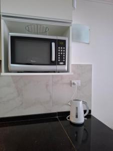 a microwave oven on a shelf in a kitchen at Quinta Luna 10 - Playa Bonita in San Carlos de Bariloche