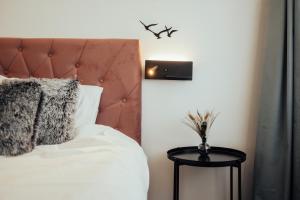 a bedroom with a white bed with a brown headboard at Lake View stay, stunning sunrises & free parking in Liepāja