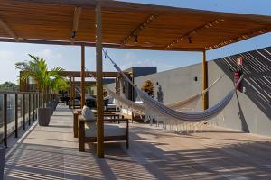 a deck with hammocks and chairs on a roof at Flats Beira-Mar na Rota dos Milagres - Essence Tatuamunha in Pôrto de Pedras