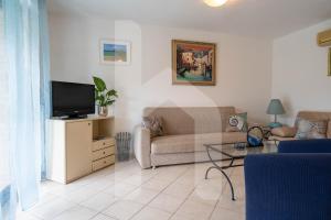 ein Wohnzimmer mit Sofa und Fernseher in der Unterkunft Homiday - Green Bay Village in Pineto