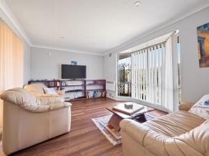 ein Wohnzimmer mit zwei Sofas und einem Fernseher in der Unterkunft Leeuwin Cottage in Augusta