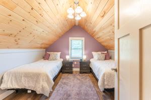 a attic bedroom with two beds and a window at White Fern in New Waterford