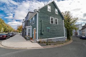 a green house on the corner of a street at The Bannerman Park Suite And Loft in St. John's