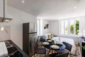 a kitchen and living room with a table and chairs at Le Cocon - parking privé in Attignat