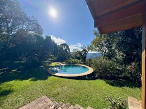 a small swimming pool in the yard of a house at Lindo sítio com piscina, quadra de tênis e lago in Nova Petrópolis