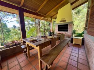 a dining room with a table and a fireplace at Lindo sítio com piscina, quadra de tênis e lago in Nova Petrópolis