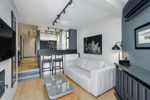 a living room with a white couch and a bar at Flat Wish Serrano by Achei Gramado in Gramado