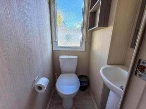 een kleine badkamer met toilet en wastafel bij Stunning 8 Berth Caravan At Cherry Tree Holiday Park In Norfolk Ref 70711C in Great Yarmouth +12 foto's