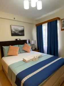 a bedroom with a large bed with blue and orange pillows at Executive Studio Condo Unit 2 at Marina Spatial in Piapi +19 photos