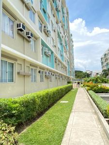 an apartment building with grass next to a sidewalk at Executive Studio Condo Unit 2 at Marina Spatial in Piapi