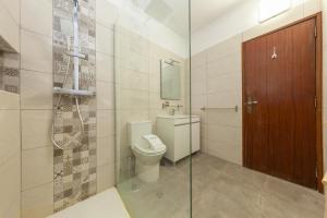 um banheiro com vaso sanitário e box de vidro em Praia da Rocha Beach Step em Portimão mais 38 fotografias