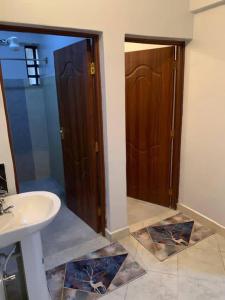 ein Bad mit einem Waschbecken, einem WC und einer Tür in der Unterkunft Bnb in Thuthuriki