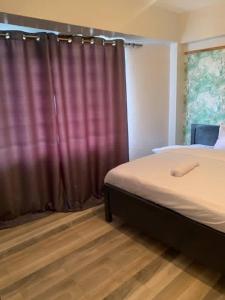 ein Schlafzimmer mit einem Bett und einem roten Vorhang in der Unterkunft Bnb in Thuthuriki