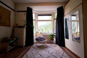 een woonkamer met een groot raam en een stoel bij Olympic's Little Palace in Amsterdam