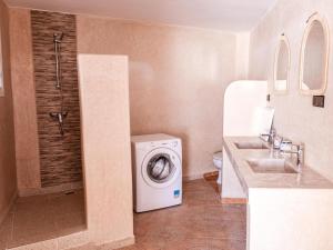 a bathroom with a washing machine and a sink at Berber Shelter in Tamraght Ouzdar
