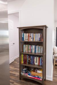 a book shelf filled with books in a room at Creek View Cottage in Berry