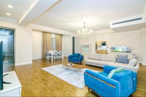 a living room with a couch and blue chairs at Luxary Home VIP Hillton in Baku