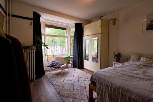 a bedroom with a bed and a large window at Olympic's Little Palace in Amsterdam