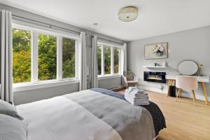 a bedroom with a large bed and two windows at Pennywell Prestige 3 Bed 15 Bath Garage in St. John's