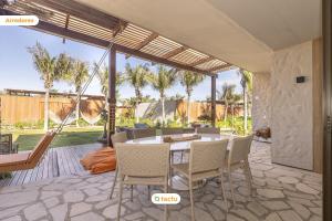 an outdoor patio with a table and chairs at Origem Fortim - Suítes Climatizadas e Lazer in Maceio