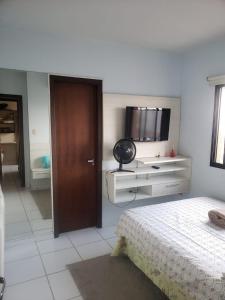 a bedroom with a bed and a television on the wall at Apartment no Centro in Belém