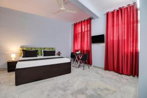 a bedroom with a large bed with red curtains at Hotel O Blue moon in New Delhi
