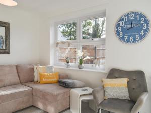 a living room with a couch and a clock on the wall at Apartment 1 - Uk42622 in Poole