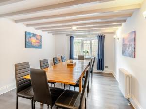 a dining room with a wooden table and chairs at Northstead Lodge in Flamborough