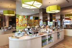 a restaurant kitchen with dishes on a counter at Zest Sukajadi Bandung by Swiss-Belhotel International in Bandung