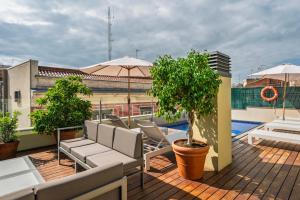 a balcony with chairs and a tree on a roof at Aspasios Catedral Apartments in Barcelona