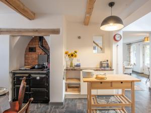 a kitchen with a wooden table and a stove at Top House in Forden