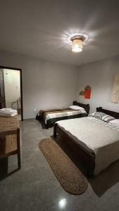 a bedroom with two beds and a chandelier at Casa do Kite in Cumbuco