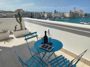 una mesa con una botella de vino y copas en el balcón en CconfortHotels Sea Dream Palace 2, en Trani
