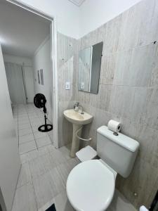 a white bathroom with a toilet and a sink at Apartamento Central 2 quartos e 2 banheiros, perto shopping in Juazeiro +21 photos