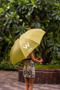 a woman is holding an umbrella in the rain at W Goa in Vagator