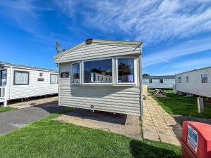 a tiny house is sitting in the grass at Superb 8 Berth Caravan, Close To Amenities At Caister Beach Ref 30073F in Great Yarmouth