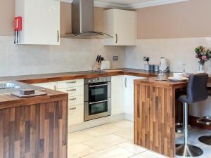 a kitchen with white cabinets and wooden counter tops at Alfie's Abode in Ingoldmells
