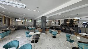 a restaurant with tables and chairs in a room at Sim Plaza Hotel in Ejmiatsin