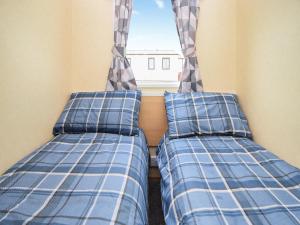 two beds in a room with a window at J And M Retreat in Morecambe