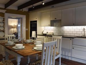 a kitchen with a wooden table and white cabinets at The Haven in Holy Island