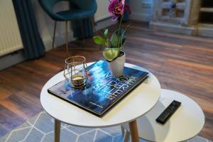 a book on a table with a vase and a candle at Nurban Apartments City Nürnberg in Nürnberg
