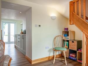 a kitchen with a staircase and a chair in a room at Trelawney Cottage in Charlestown