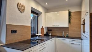 a kitchen with white cabinets and a black counter top at Appartement HARRIE by Miha in Westendorf